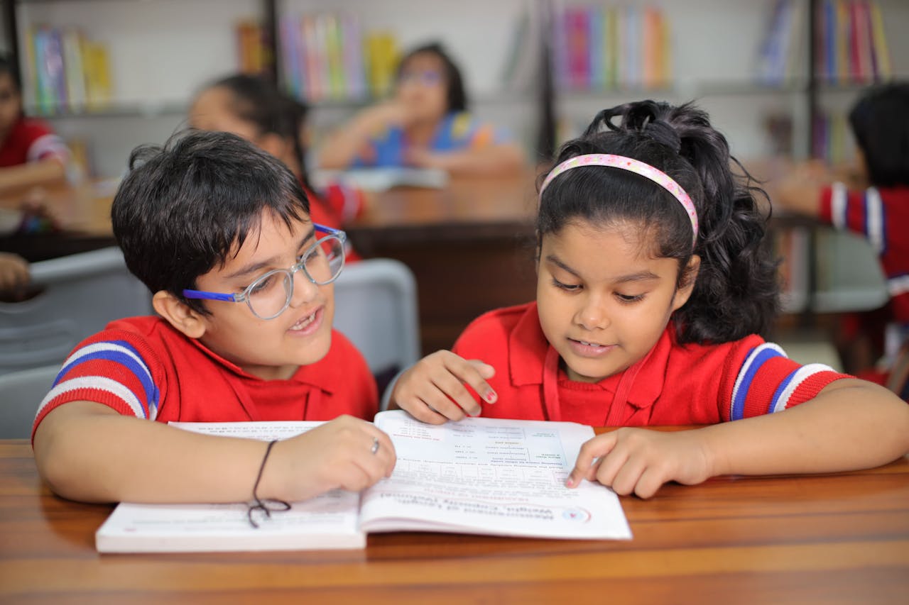 portfolio-05 Two young children reading together in a bright classroom in Gurugram, India.