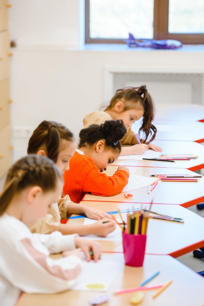 portfolio-01 Group of children focused on schoolwork in a bright classroom setting.